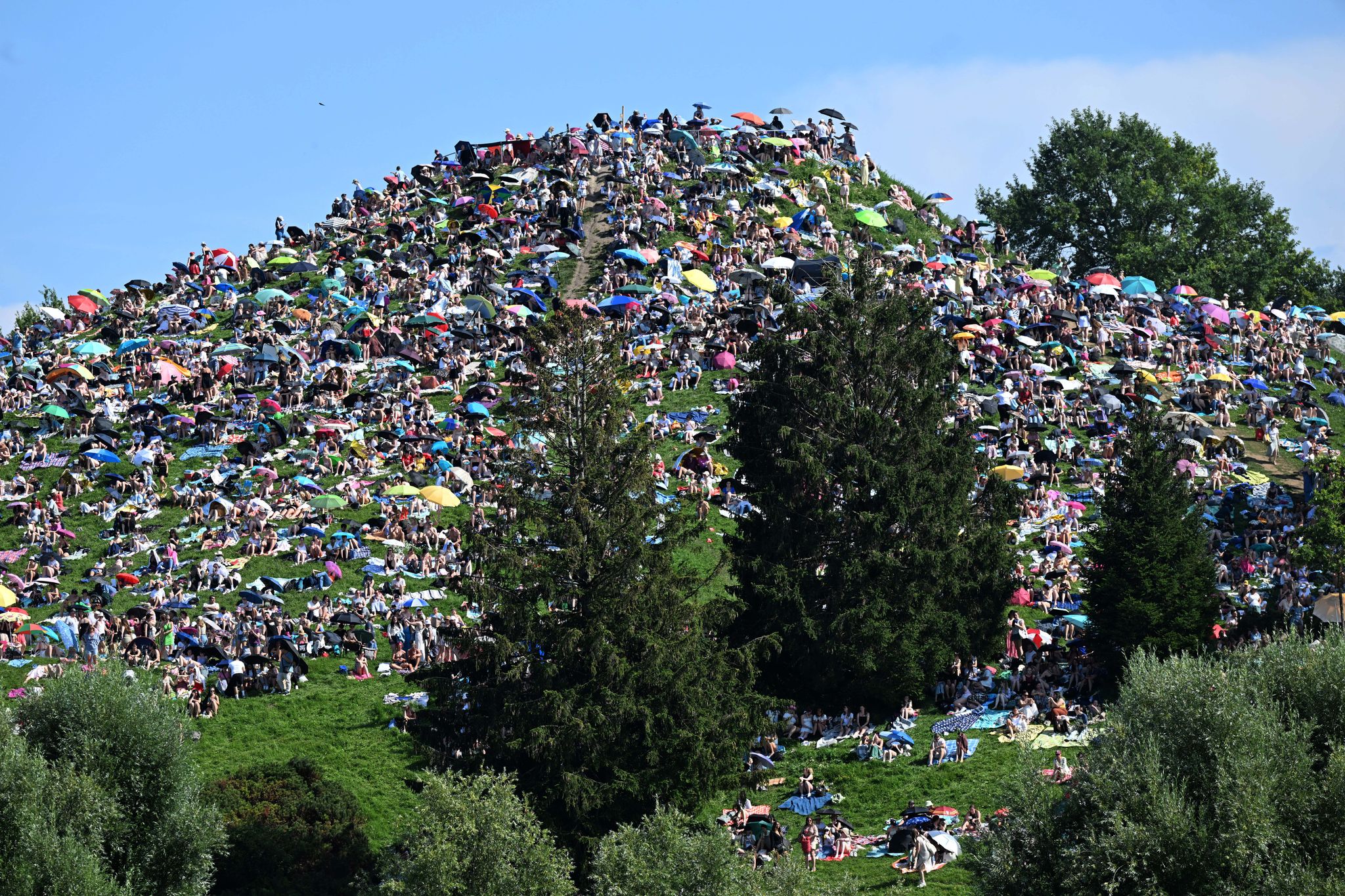 Viele Menschen ohne Ticket verfolgten Taylor Swifts Konzert in München von einem Hügel neben dem Stadion aus. Foto: Felix Hörhager/dpa