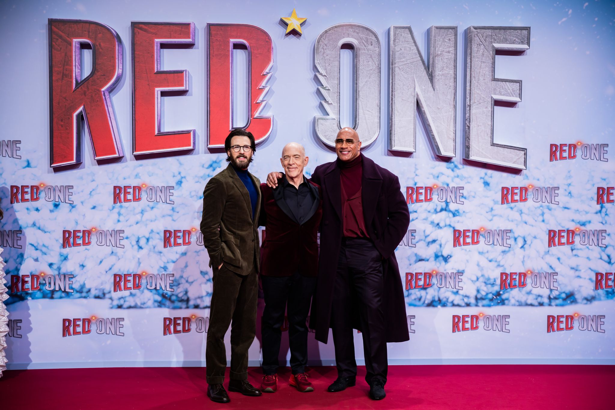 Chris Evans (l-r), J.K. Simmons und Dwayne Johnson auf dem Roten Teppich zur Weltpremiere des Films «Red One – Alarmstufe Weihnachten».  Foto: Christoph Soeder/dpa